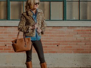 woman wearing leopard jacket with denim shirt and tan accessories