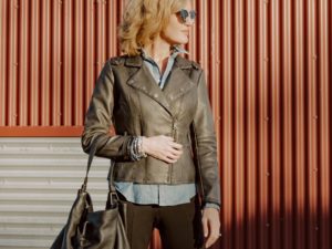 Woman wearing faux leather coat with blue shirt